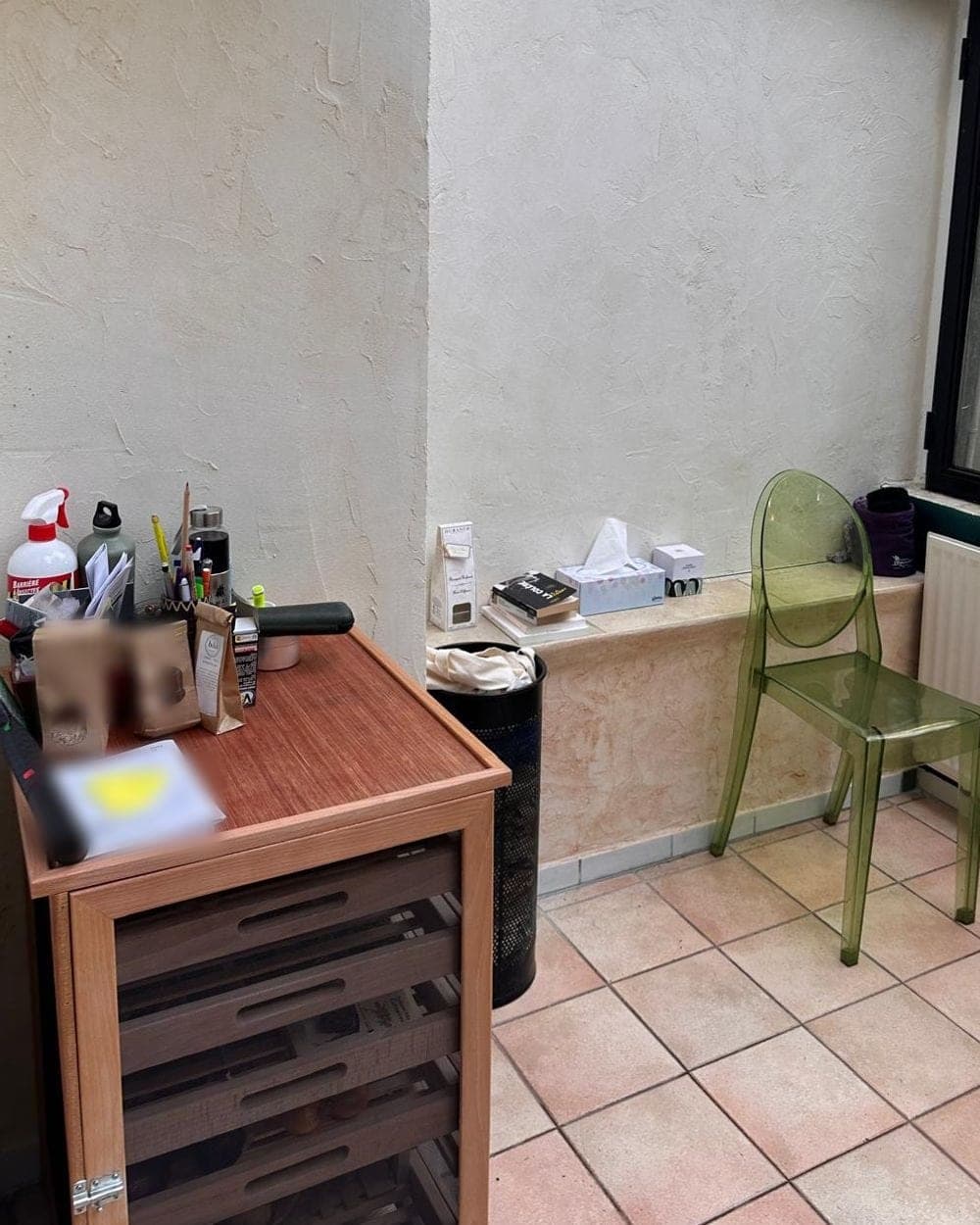 Coin de véranda après le passage : meuble à tiroirs sans pile de linge, chaise verte et radiateur